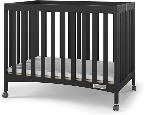 Child Craft London Mini Compact Folding Portable Crib with 2 Crib Mattress and 2 Easy Roll Locking Wheels, Durable Pine Wood Construction (Ebony Black)
